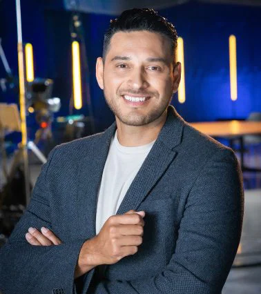 A smiling man in a suit embodies the spirit of empowering diverse small businesses.